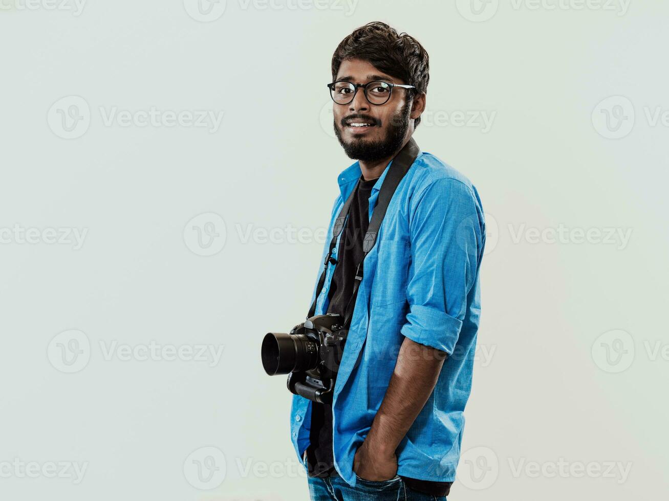 Fachmann Fotograf haben dslr Kamera nehmen Bild.indisch Mann Fotografie Enthusiast nehmen Foto während Stehen auf Blau Hintergrund. Studio Schuss