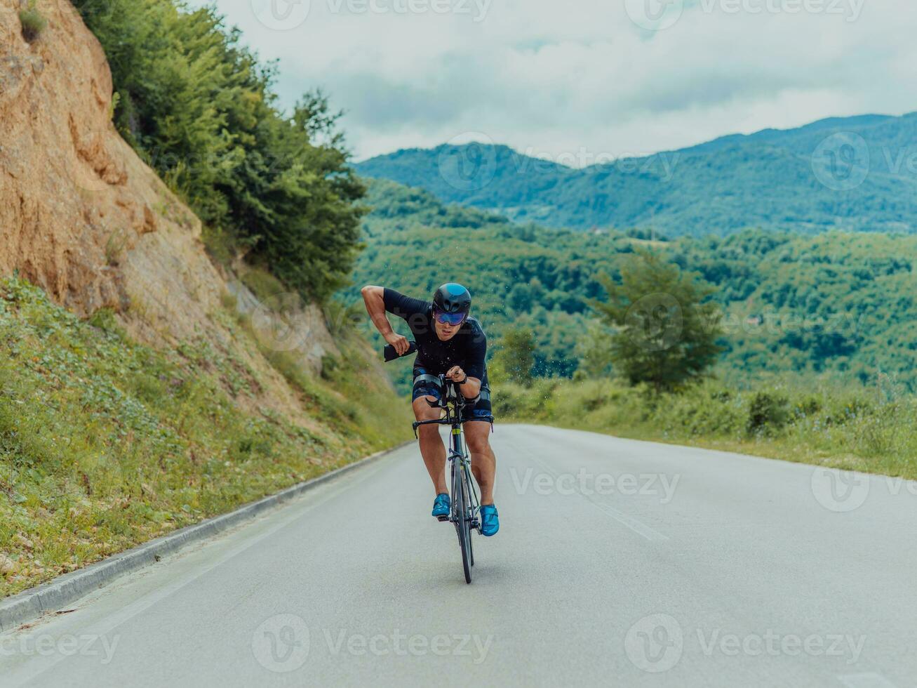 voll Länge Porträt von ein aktiv Triathlet im Sportbekleidung und mit ein schützend Helm Reiten ein Fahrrad. selektiv Fokus foto