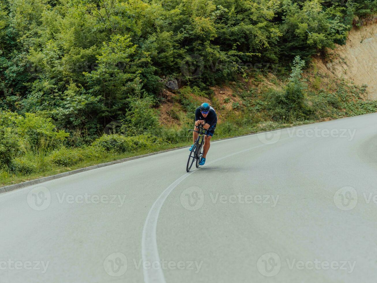 voll Länge Porträt von ein aktiv Triathlet im Sportbekleidung und mit ein schützend Helm Reiten ein Fahrrad. selektiv Fokus foto