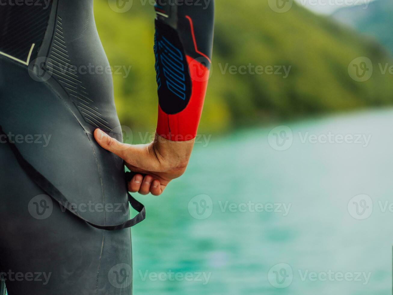 Athlet Putten auf ein Schwimmen passen und vorbereiten zum Triathlon Schwimmen und Ausbildung im das Fluss umgeben durch natürlich Grün foto