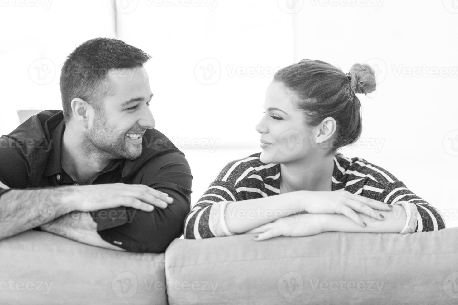 Porträt eines jungen Paares, das auf dem Sofa sitzt foto