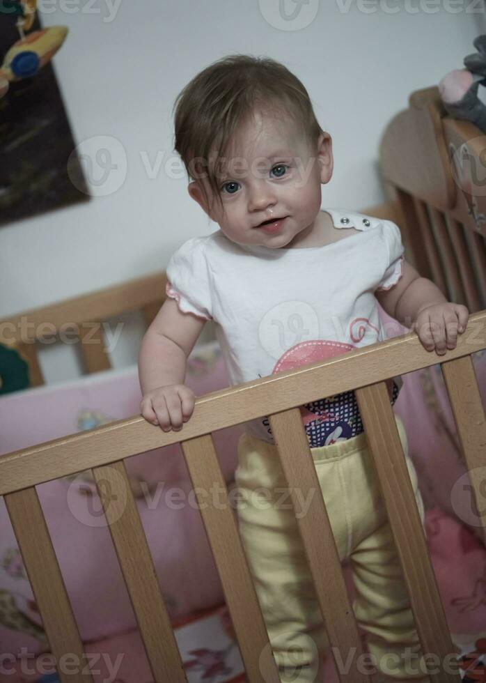 süßes kleines einjähriges baby und macht erste schritte im bett foto