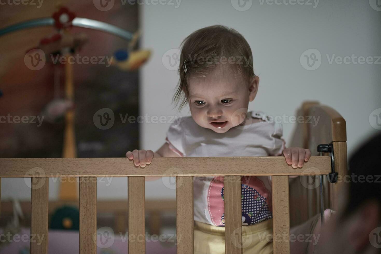 süßes kleines einjähriges baby und macht erste schritte im bett foto