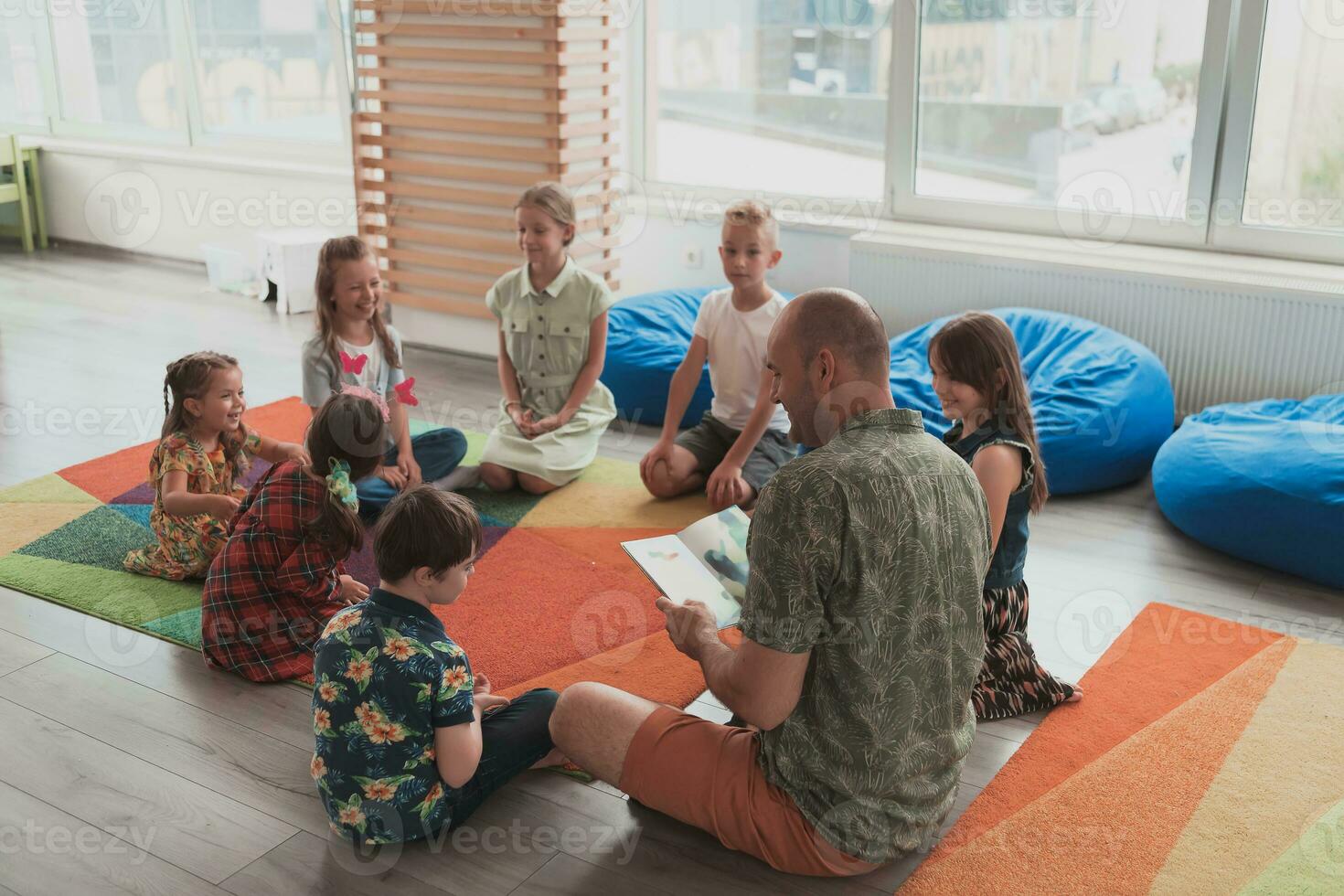 lesen Zeit im elementar Schule oder Kindergarten, Lehrer lesen ein Buch zu Kinder im elementar Schule oder Kindergarten. selektiv Fokus foto