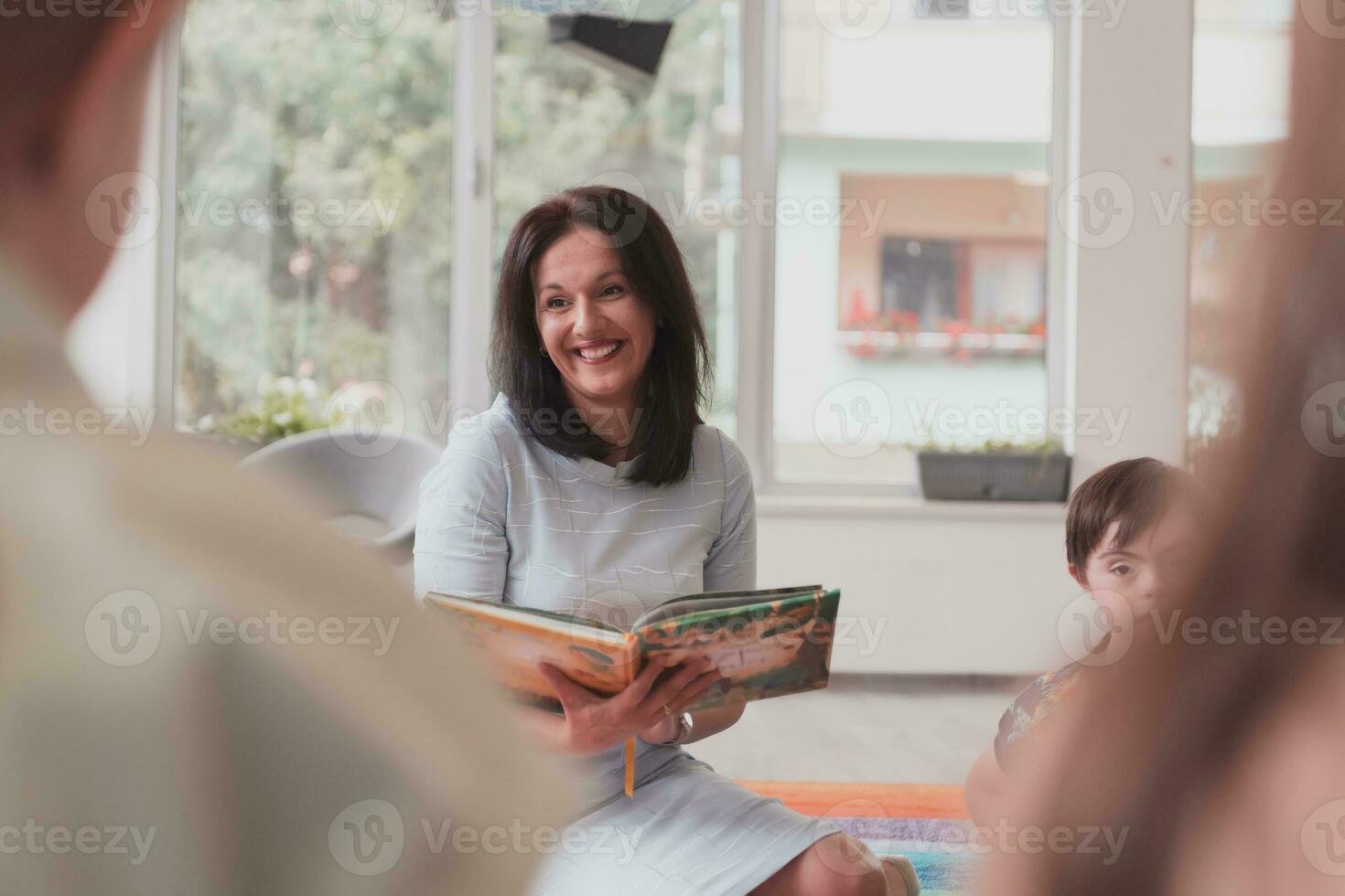 lesen Zeit im ein elementar Schule oder Kindergarten, ein Lehrer liest ein Buch zu Kinder im ein elementar Schule oder Kindergarten. das Konzept von Vorschule Bildung. selektiv Fokus foto