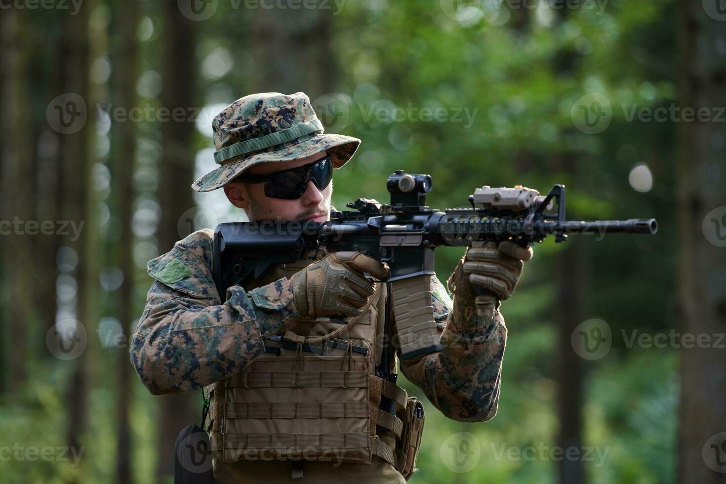 soldat in aktion, der auf waffenlaservisieroptik abzielt foto