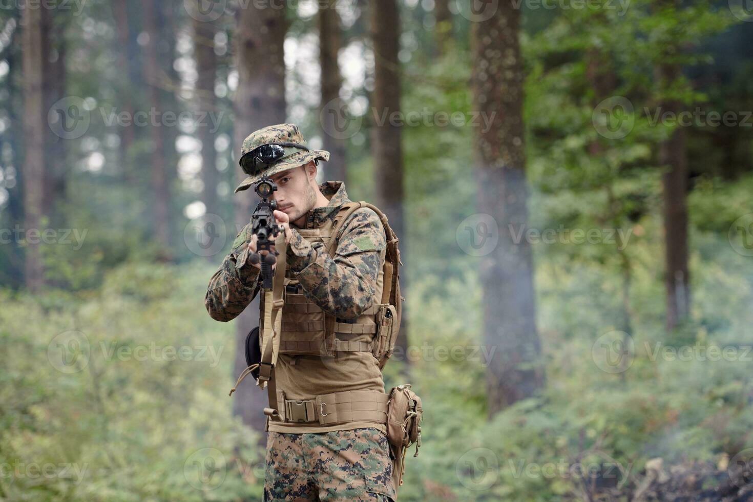 soldat in aktion, der auf waffenlaservisieroptik abzielt foto