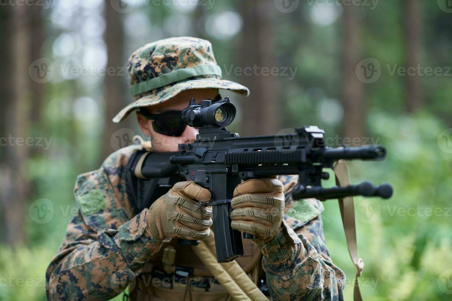 soldat in aktion, der auf waffenlaservisieroptik abzielt foto