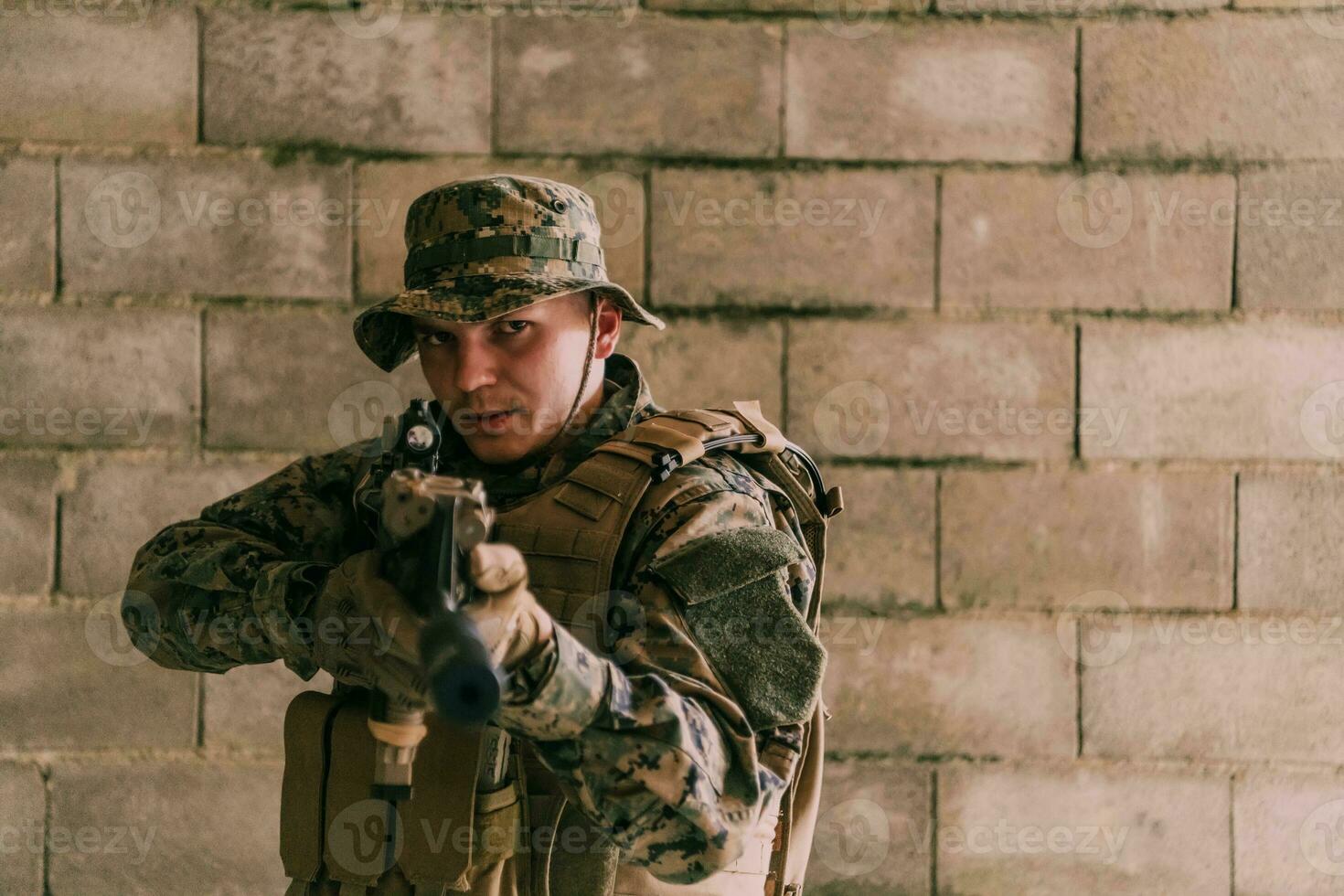 ein Soldat im Uniform steht im Vorderseite von ein Stein Mauer im voll Krieg Ausrüstung vorbereiten zum Schlacht foto