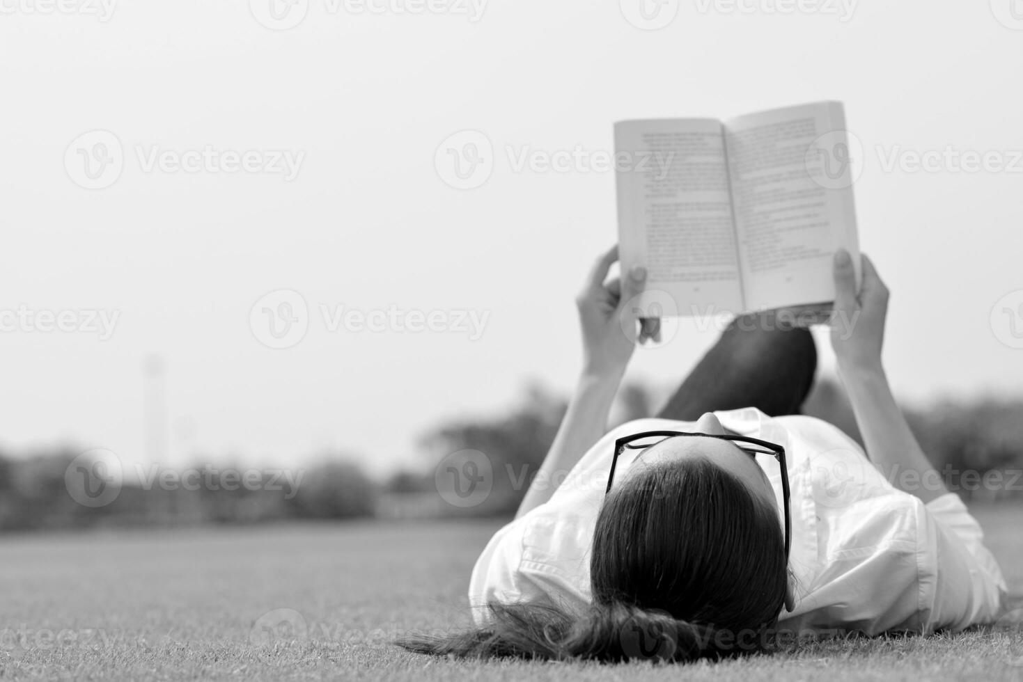 junge Frau, die ein Buch im Park liest foto