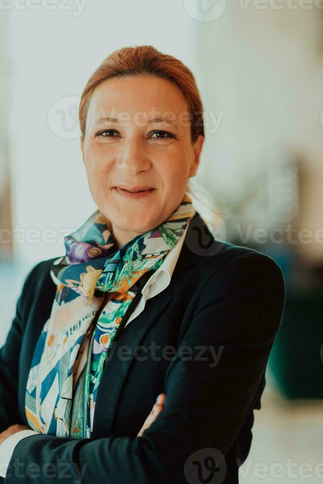 Porträt von Geschäft Senior Frau mit gekreuzt Waffen Stehen im modern Konzern. selektiv Fokus foto