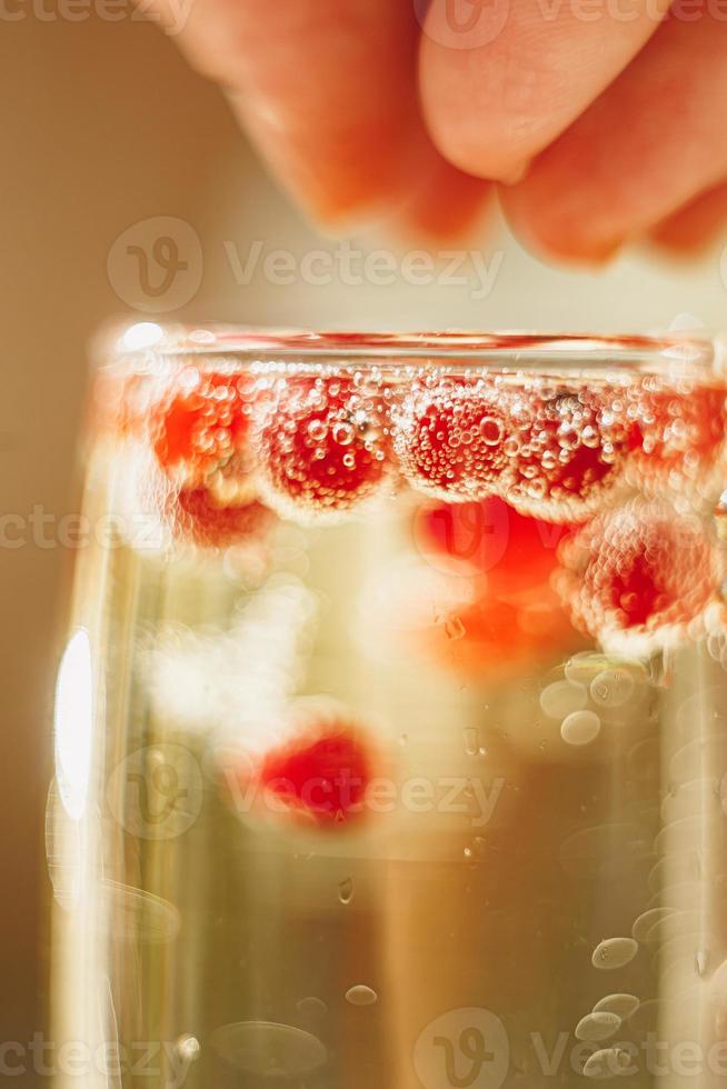 Sekt im Glas mit roten Johannisbeeren foto