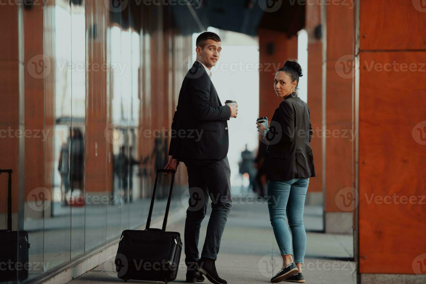 Zwei Geschäftsleute laufen durch die Stadt und trinken Kaffee foto