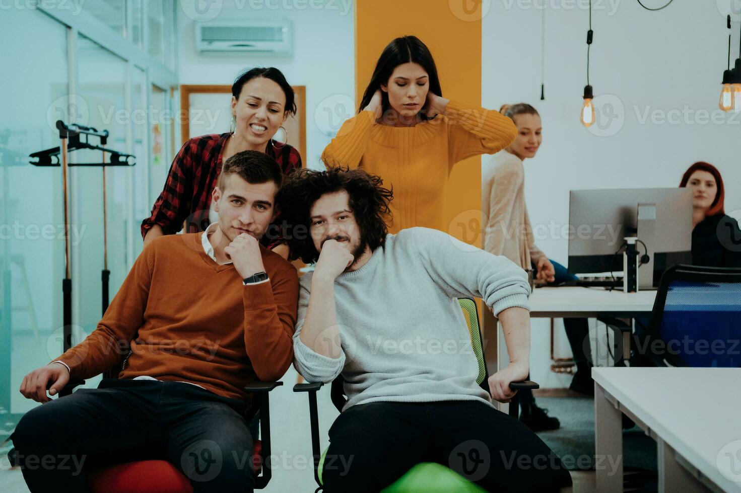 Mannschaft Gebäude und Büro Spaß. jung heiter Geschäftsleute im Clever beiläufig tragen haben Spaß während Rennen auf Büro Stühle und lächelnd. foto