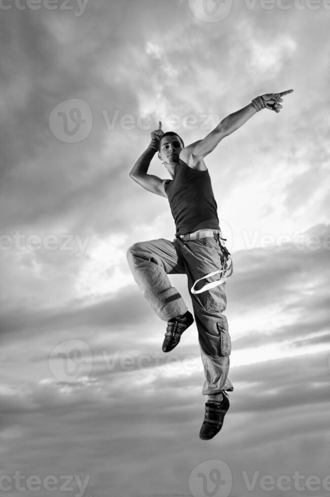 junger Mann tanzt und springt auf das Gebäude foto