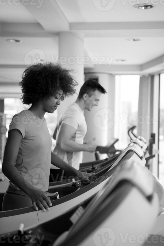 leute, die im fitnessstudio ein cardio auf dem laufband ausüben foto