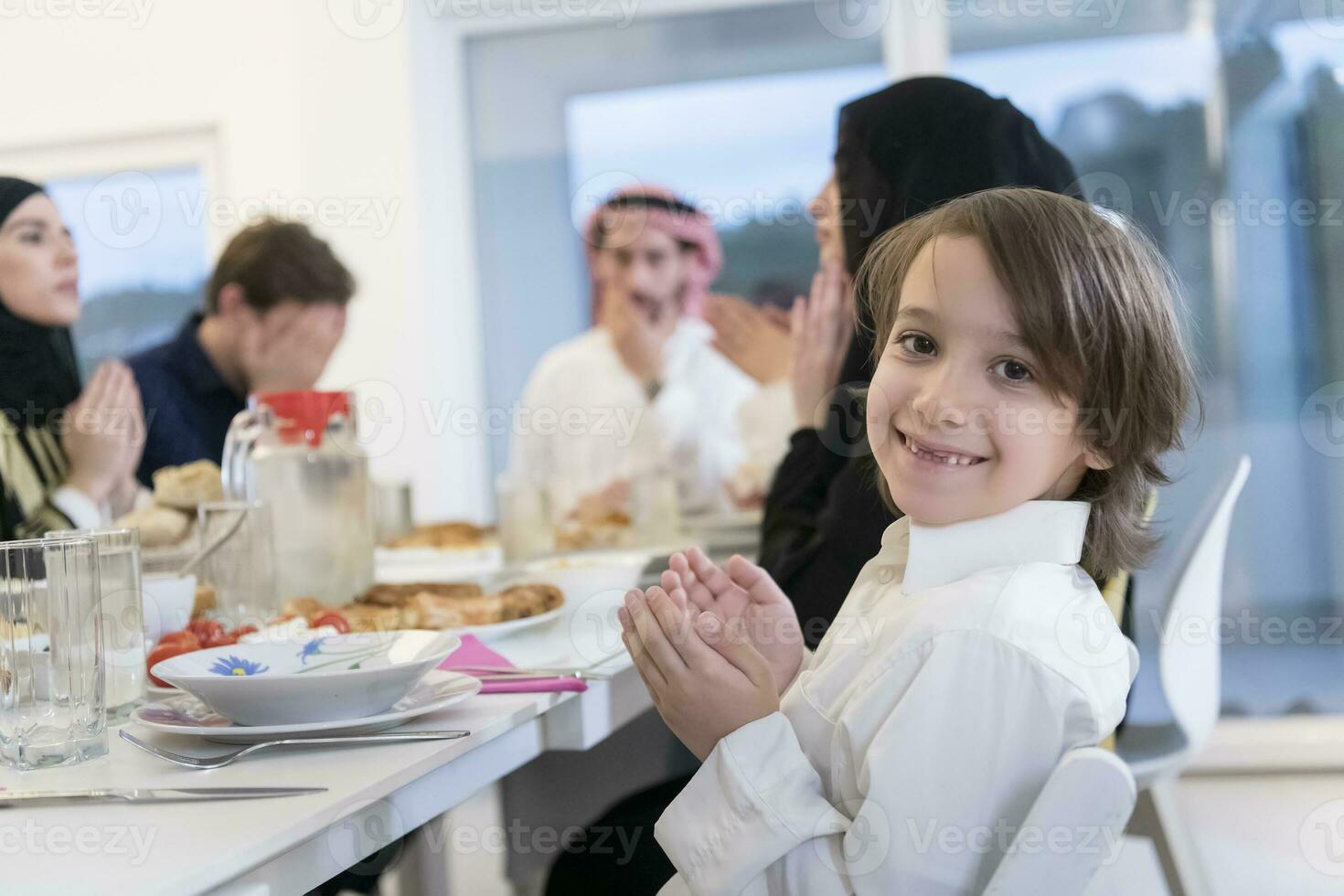 muslimische familie, die iftar dua macht, um während des ramadan das fasten zu brechen. foto