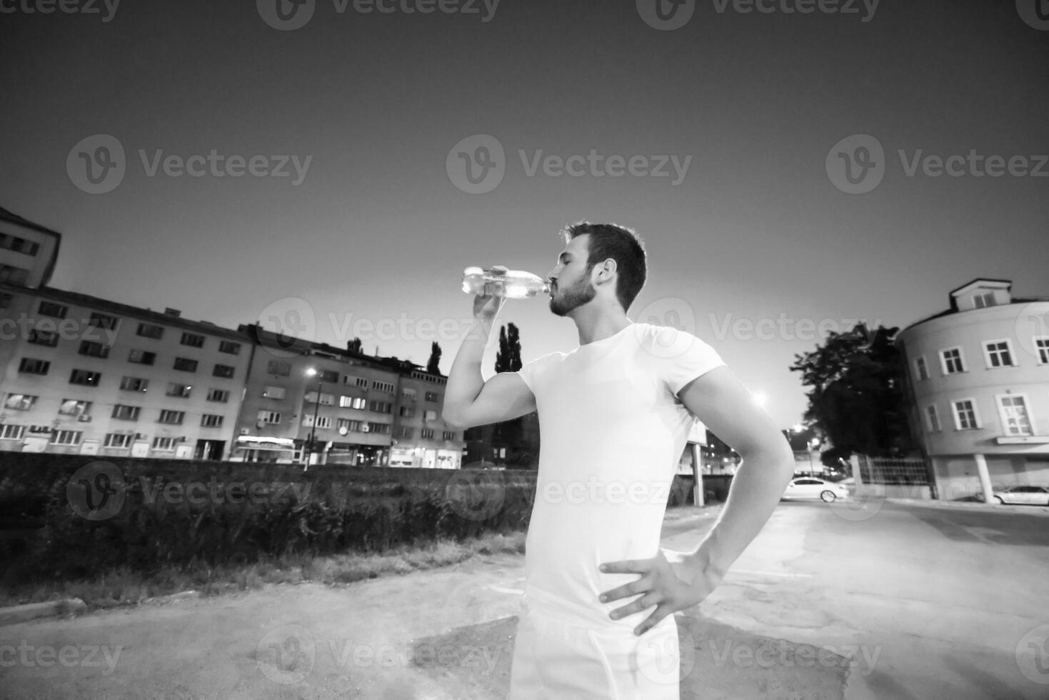 Mann trinkt Wasser nach dem Laufen foto