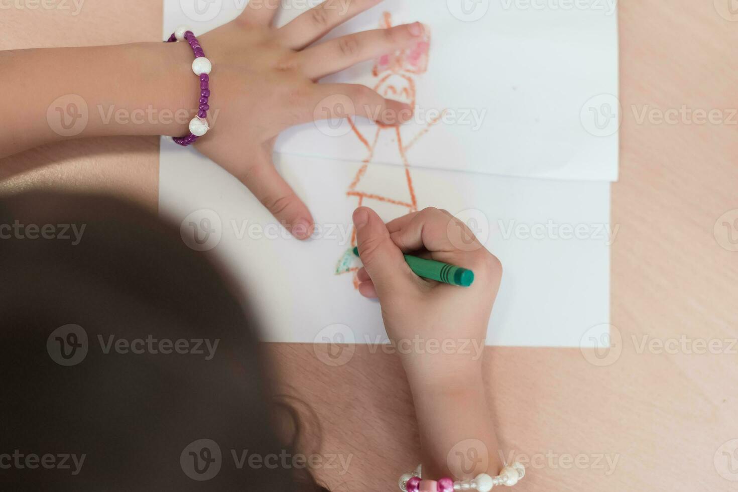 wenig Mädchen Sitzung im elementar Schule Zeichnung auf Papier foto