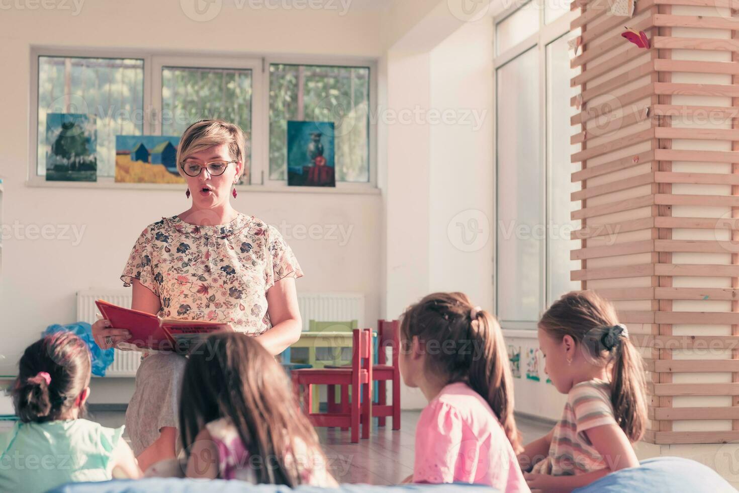 lesen Zeit im elementar Schule oder Kindergarten, Lehrer lesen ein Buch zu Kinder im elementar Schule oder Kindergarten. selektiv Fokus foto