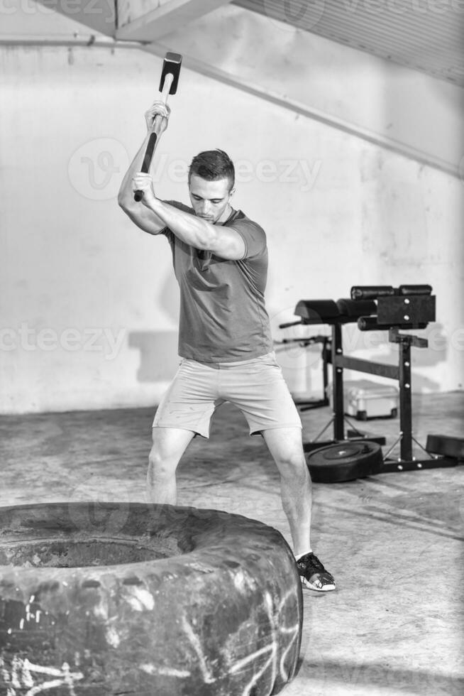 Männertraining mit Hammer und Traktorreifen foto