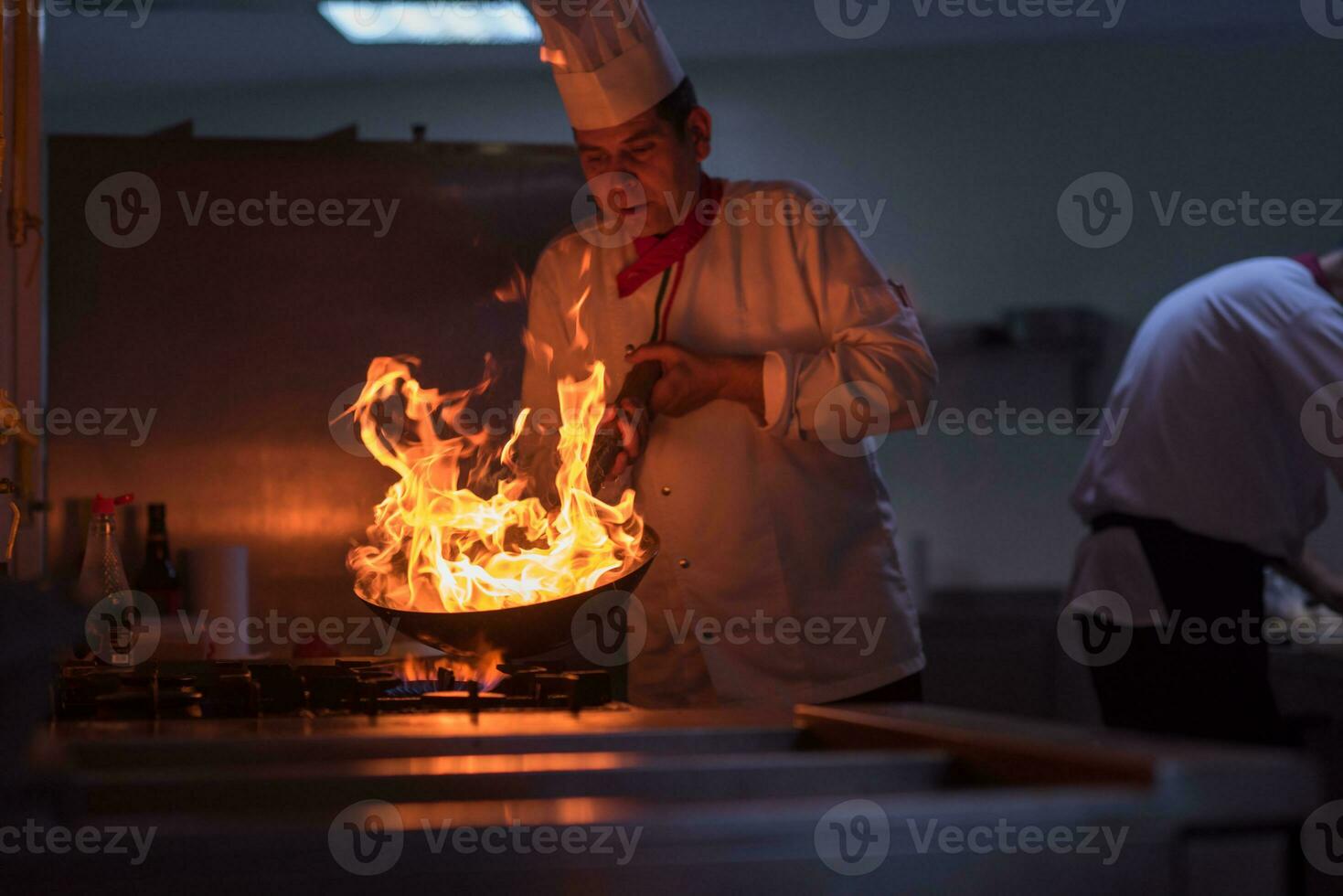 Koch macht Flamme auf Essen foto