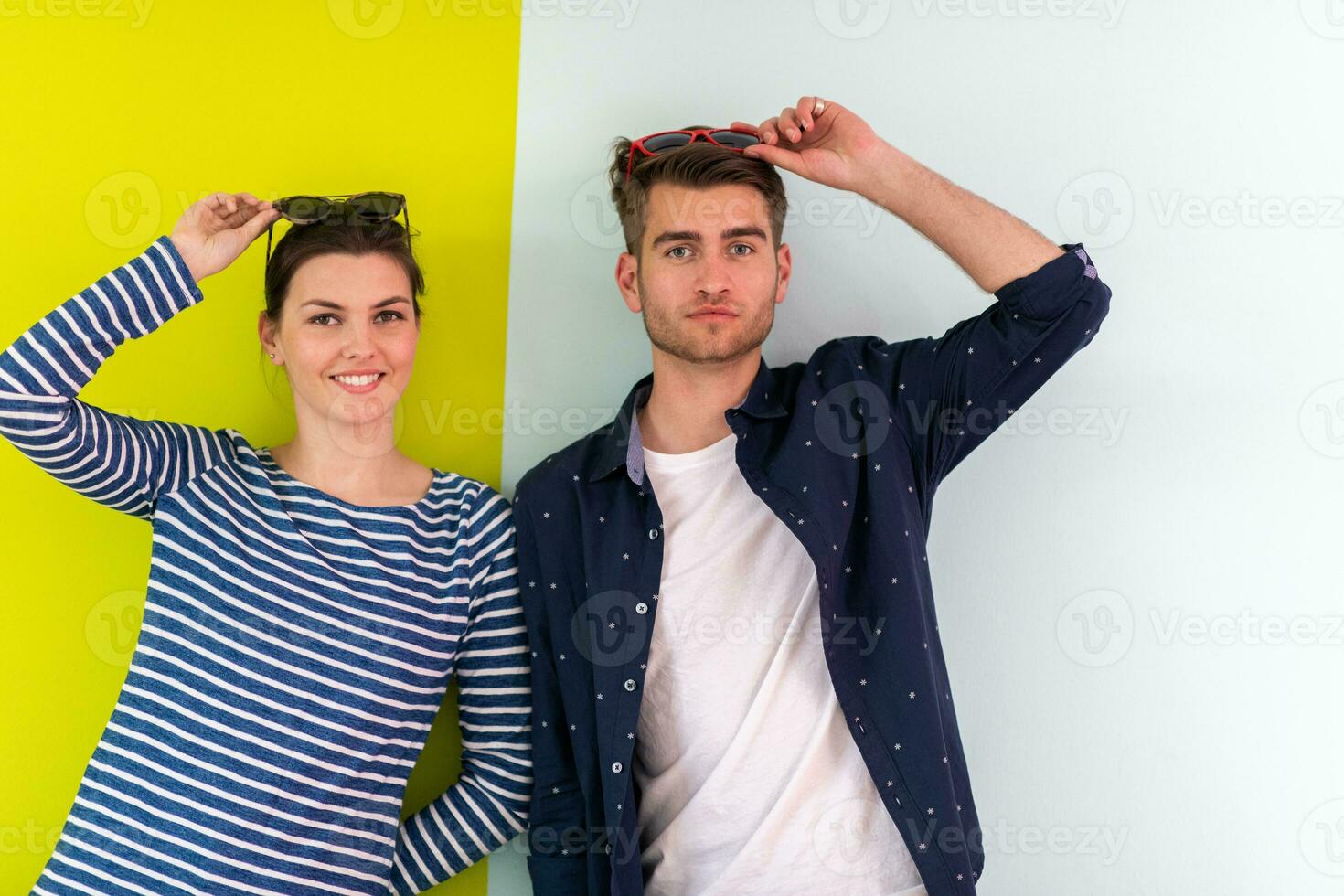 modern Mann und Mädchen tragen Sonnenbrille posieren isoliert im Vorderseite von bunt Hintergrund foto