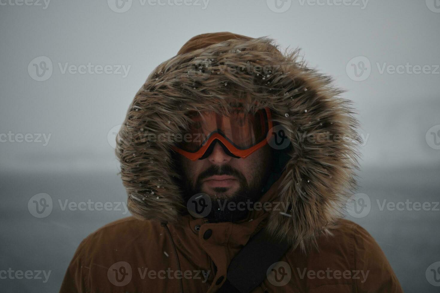 Mann im Winter bei stürmischem Wetter mit warmer Pelzjacke foto