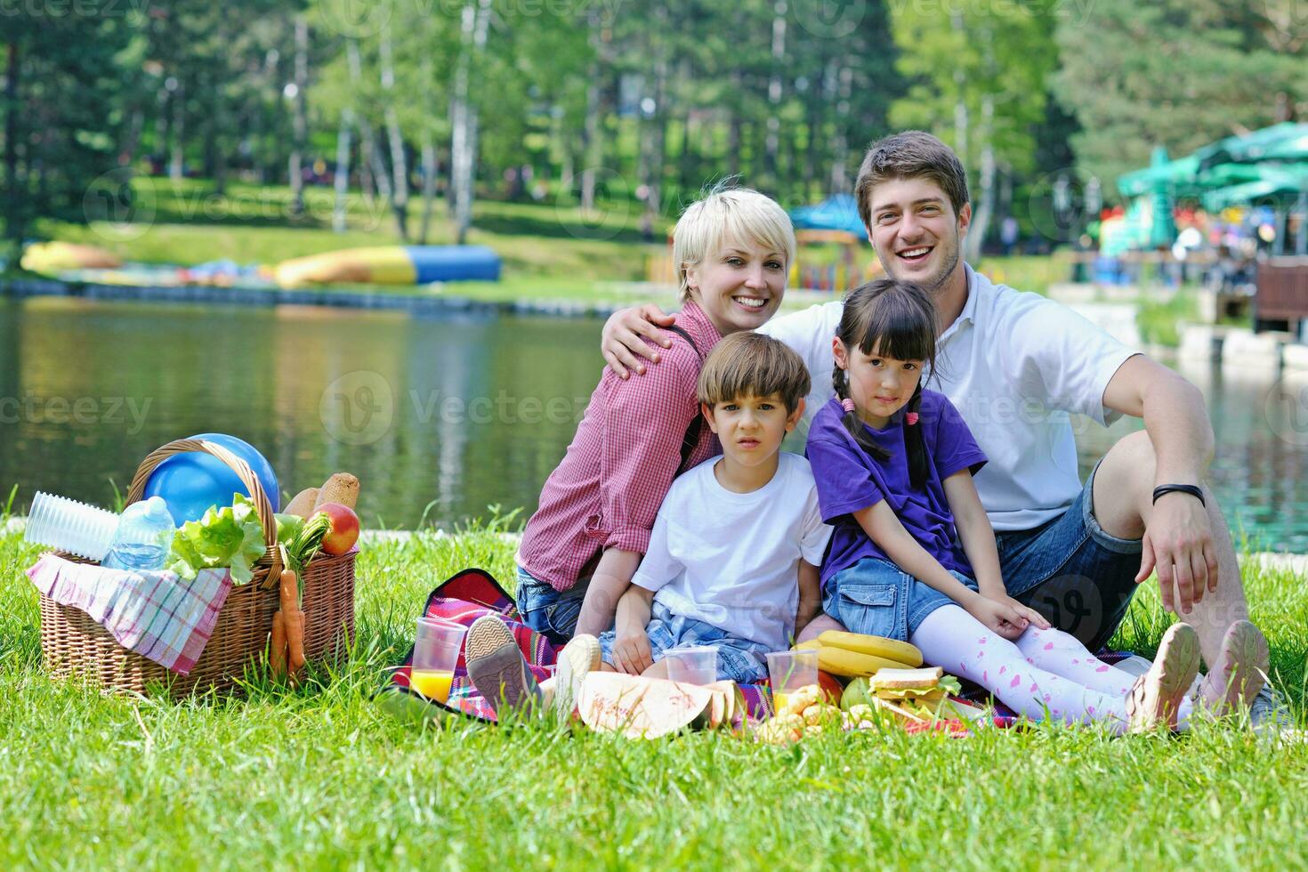 glückliche familie, die zusammen in einem picknick im freien spielt foto