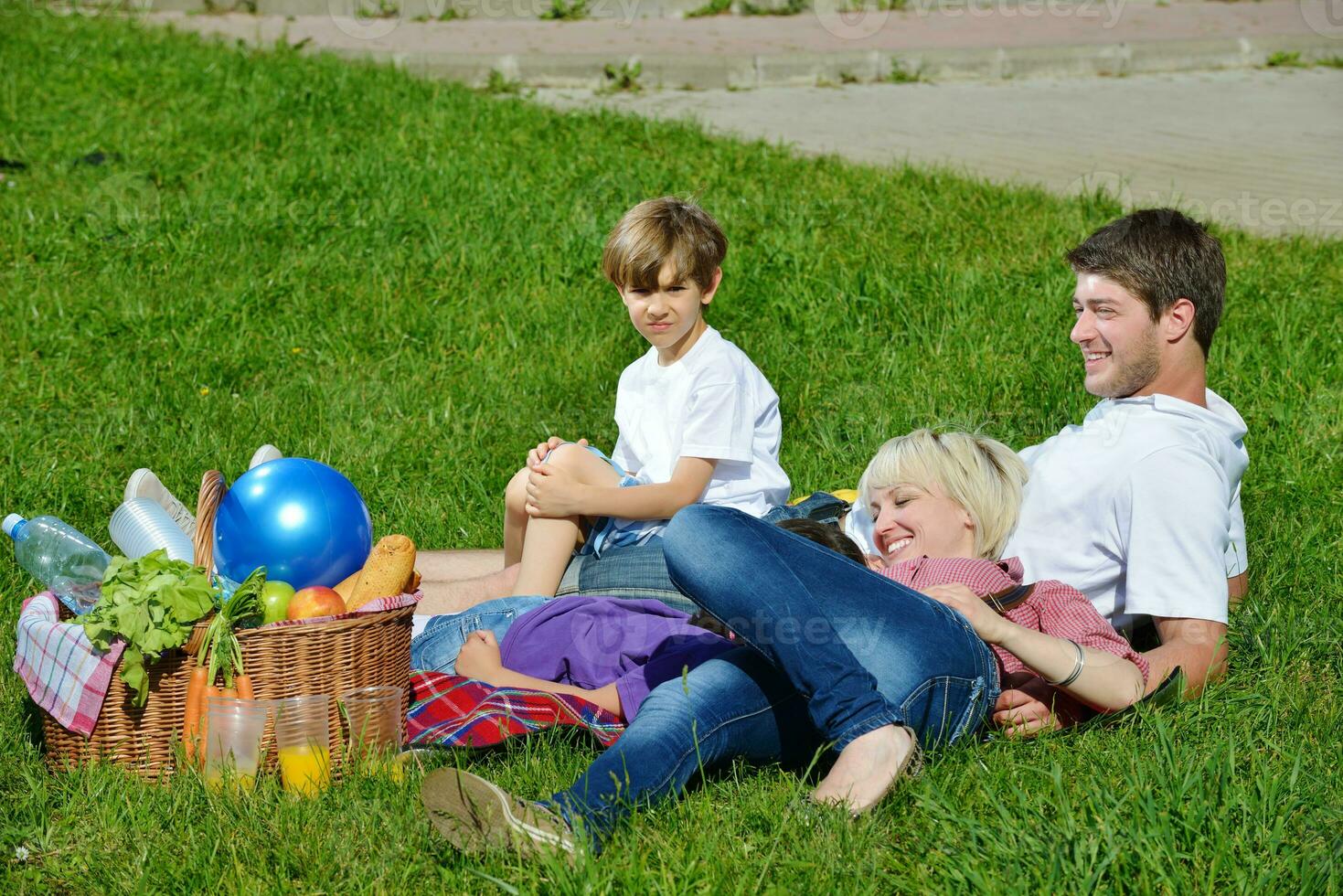 glückliche familie, die zusammen in einem picknick im freien spielt foto