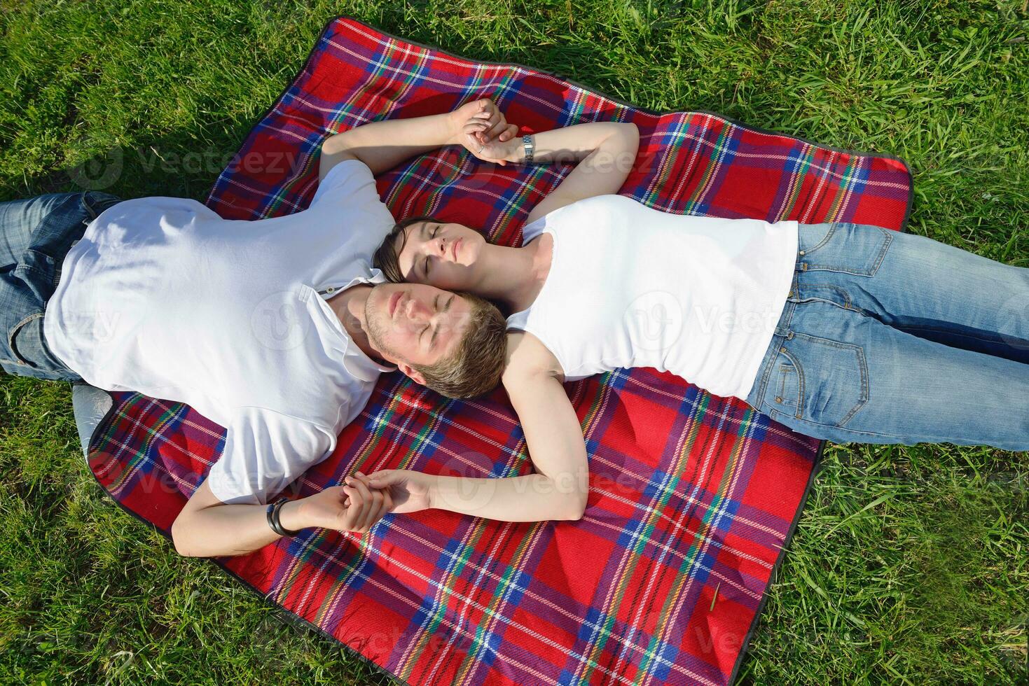 glückliches junges paar, das ein picknick im freien hat foto