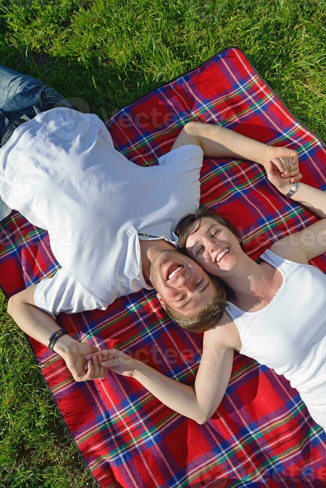 glückliches junges paar, das ein picknick im freien hat foto