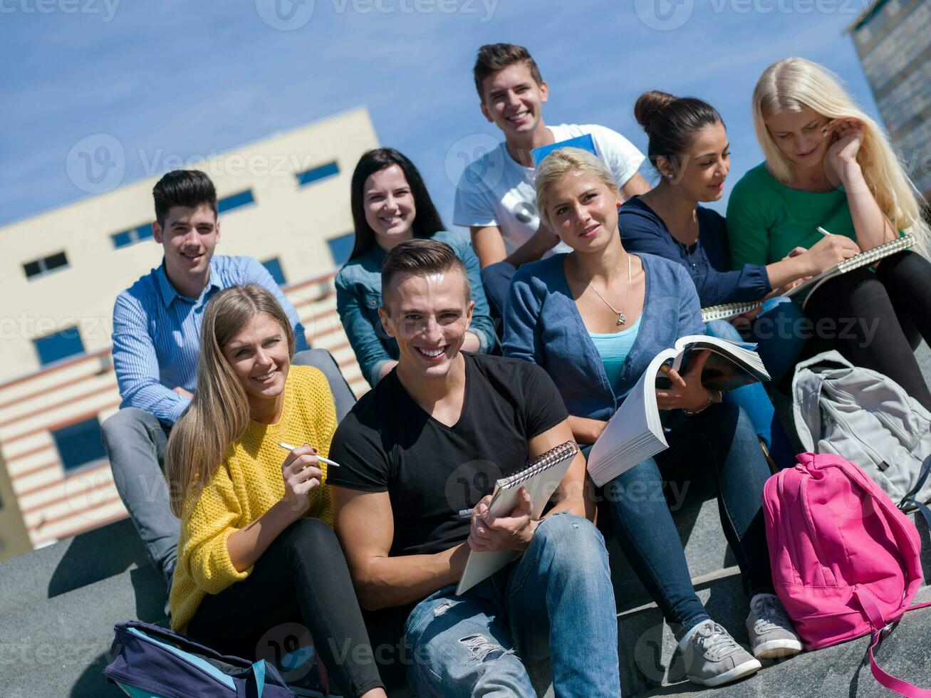 Studenten sitzen draußen auf Stufen foto