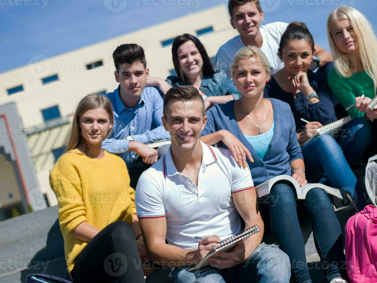 Studenten sitzen draußen auf Stufen foto