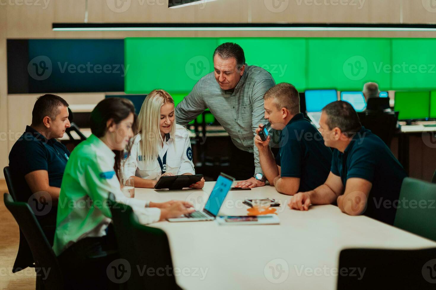 Gruppe von Sicherheit Wachen Sitzung und haben Einweisung im das System Steuerung Zimmer Sie sind Arbeiten im Sicherheit Daten Center umgeben durch mehrere Bildschirme foto