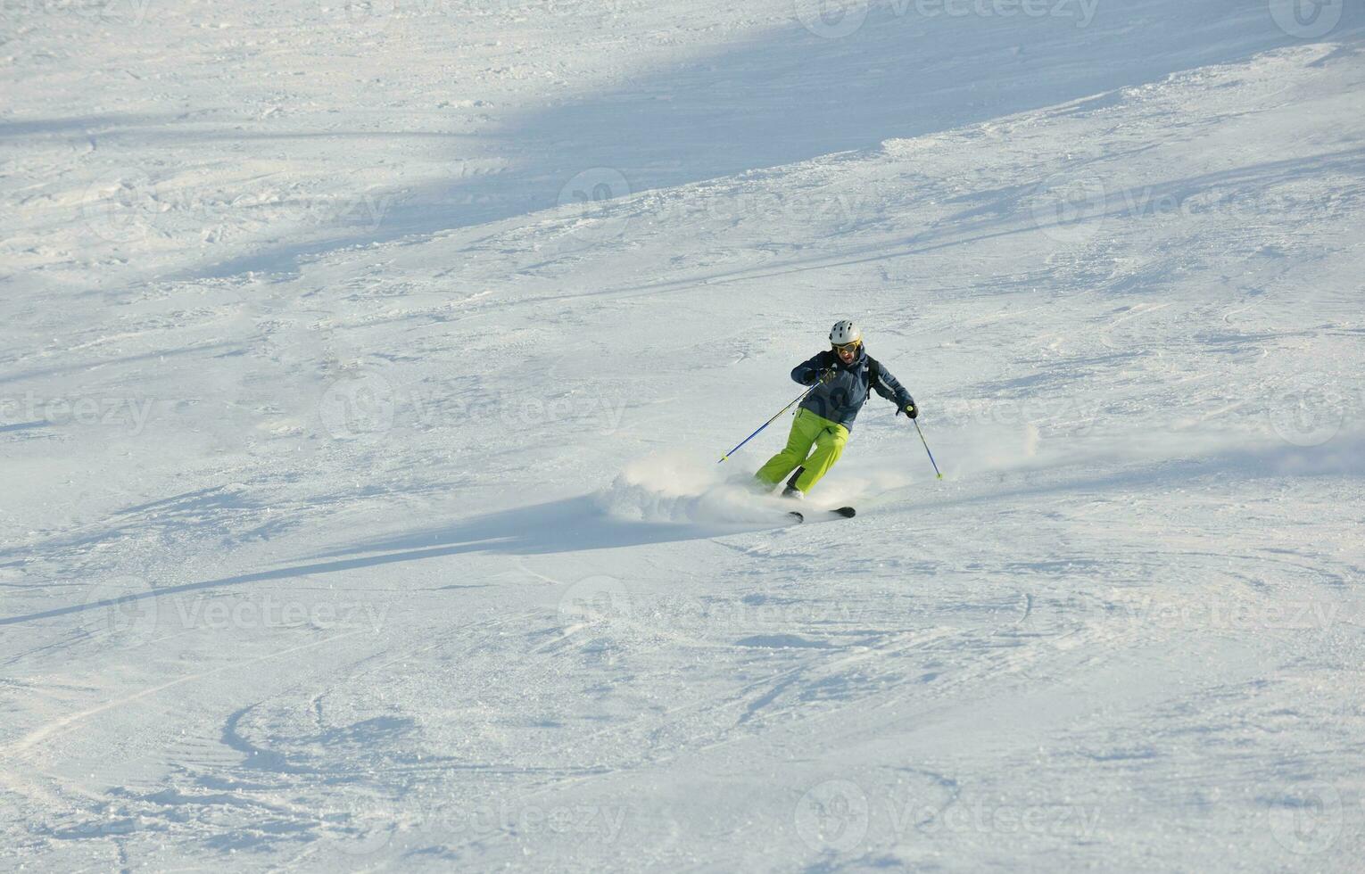 Skifahren auf Neuschnee in der Wintersaison am schönen sonnigen Tag foto