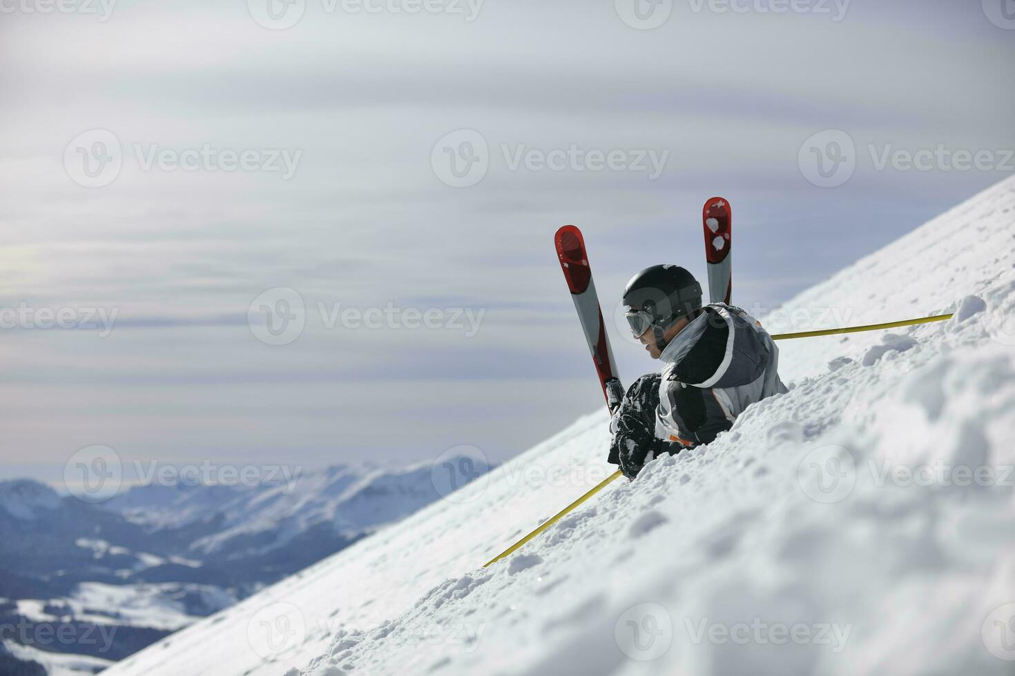 junger skifahrer, der sich am schönen sonnigen wintertag entspannt foto