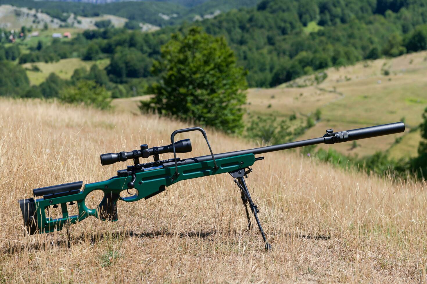 ein Grün Militär- Scharfschütze Gewehr mit ein Umfang zum lange Entfernung taktisch modern Krieg im Gelb Gras Blau Himmel foto