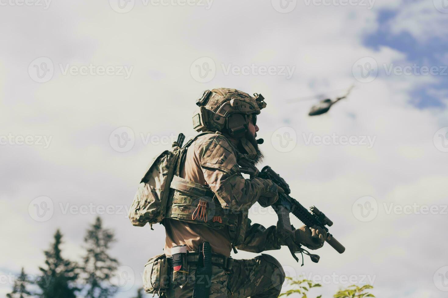 Kriegskonzept. Ein bärtiger Soldat in einer Spezialeinheit, der in einem Waldgebiet gegen einen Feind kämpft. selektiver Fokus foto