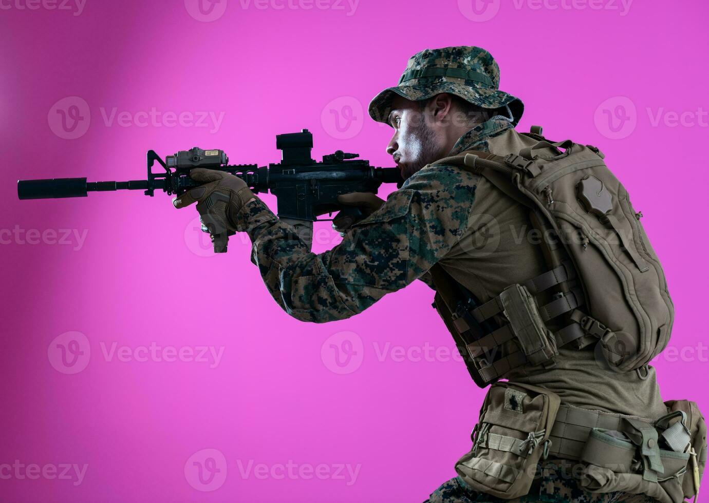 Soldat im Aktion Zielen Laser Sicht Optik Rosa Hintergrund foto
