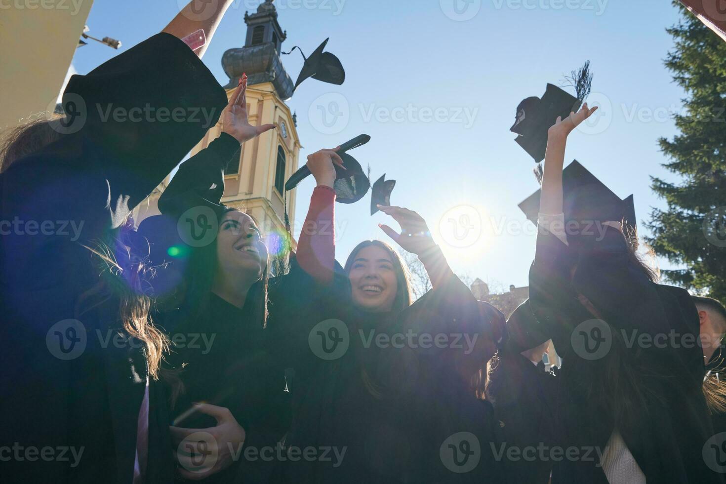 Gruppe verschiedener internationaler Absolventen, die feiern foto