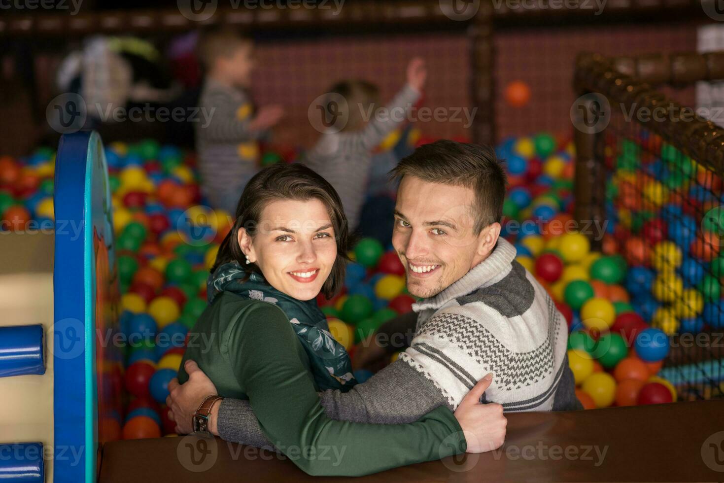 junge eltern mit kindern in einem kinderspielzimmer foto