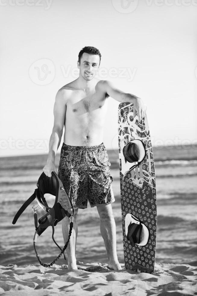 Porträt eines jungen Kitsurf-Mannes am Strand bei Sonnenuntergang foto