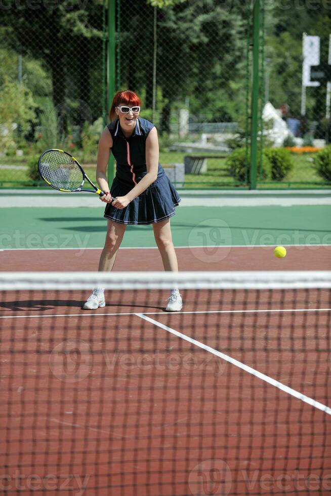 junge frau spielt tennisspiel im freien foto