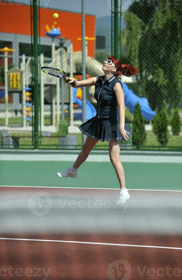 junge frau spielt tennisspiel im freien foto