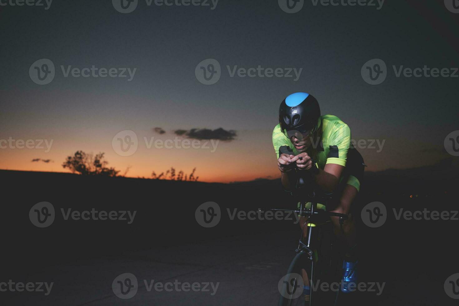 Triathlonsportler, der nachts schnell Fahrrad fährt foto