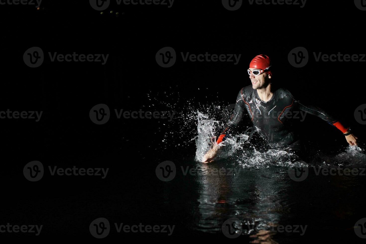Triathlon Athlet Fertigstellung Schwimmen Ausbildung beim dunkel Nacht foto