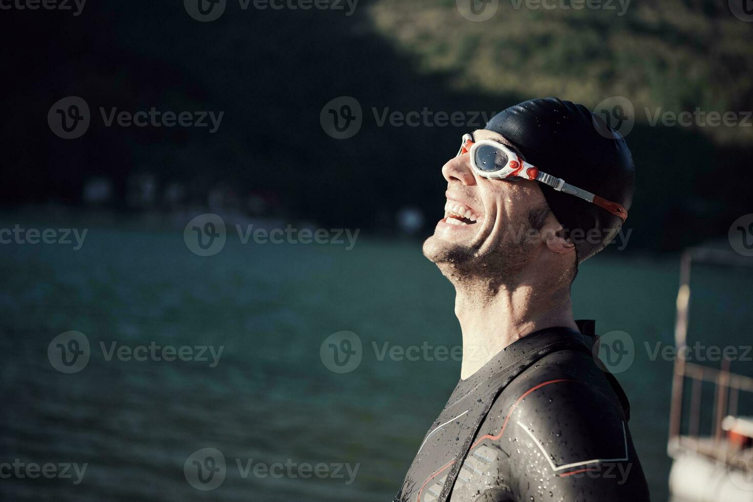 Triathlonsportler beginnt mit dem Schwimmtraining auf dem See foto