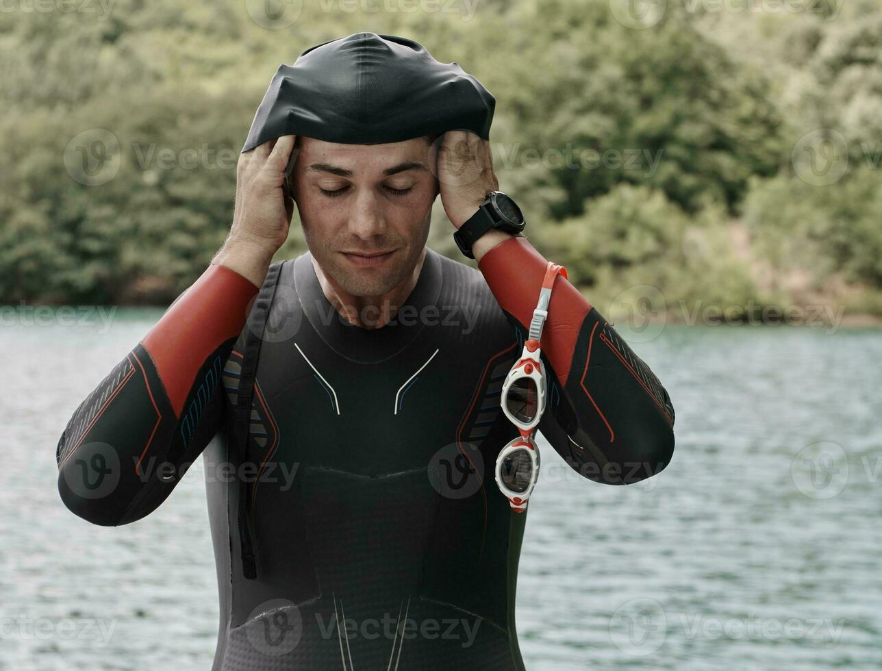 Triathlon-Athlet bereitet sich auf das Schwimmtraining auf dem See vor foto