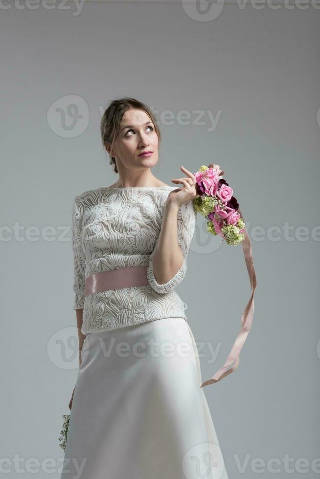 Braut mit einem Blumenstrauß isoliert auf weißem Hintergrund foto